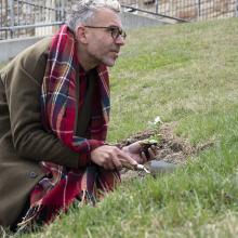 Artist Paul Hartfleet plants a pansy by the Campanile on KU's campus to mark an incident of homophobic abuse