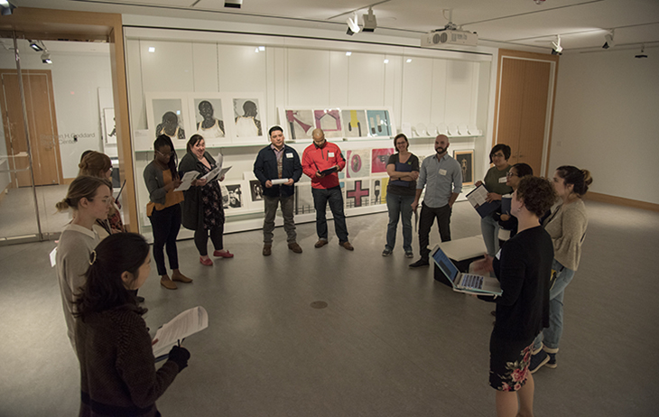 Students stand in a circle in a gallery with art