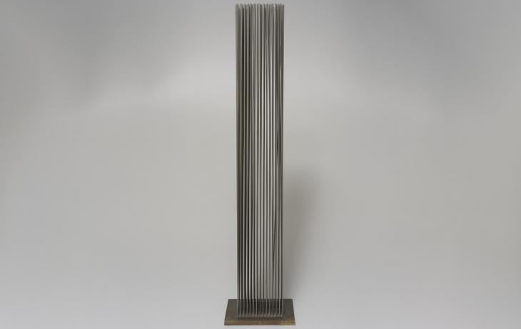 Many long thin flexible metal rods welded vertically in a grid to a base 