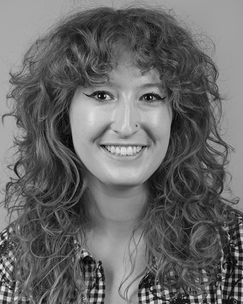 smiling light-skinned young woman with curly hair