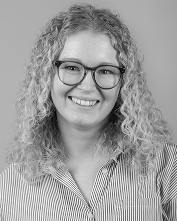 smiling light-skinned young woman with curly blonde hair