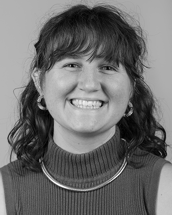 smiling light-skinned young woman with wavy dark hair