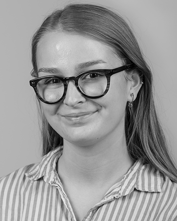 smiling light-skinned young woman with straight hair and glasses