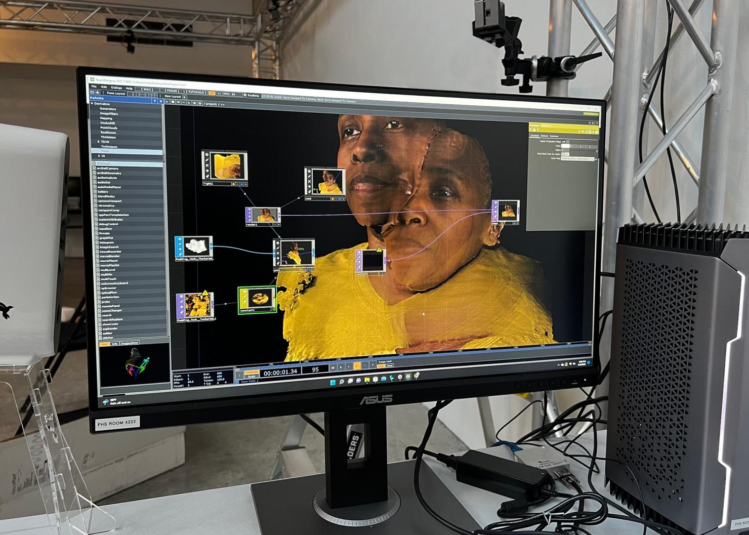 A computer screen displays a photo of a black woman wearing a yellow shirt