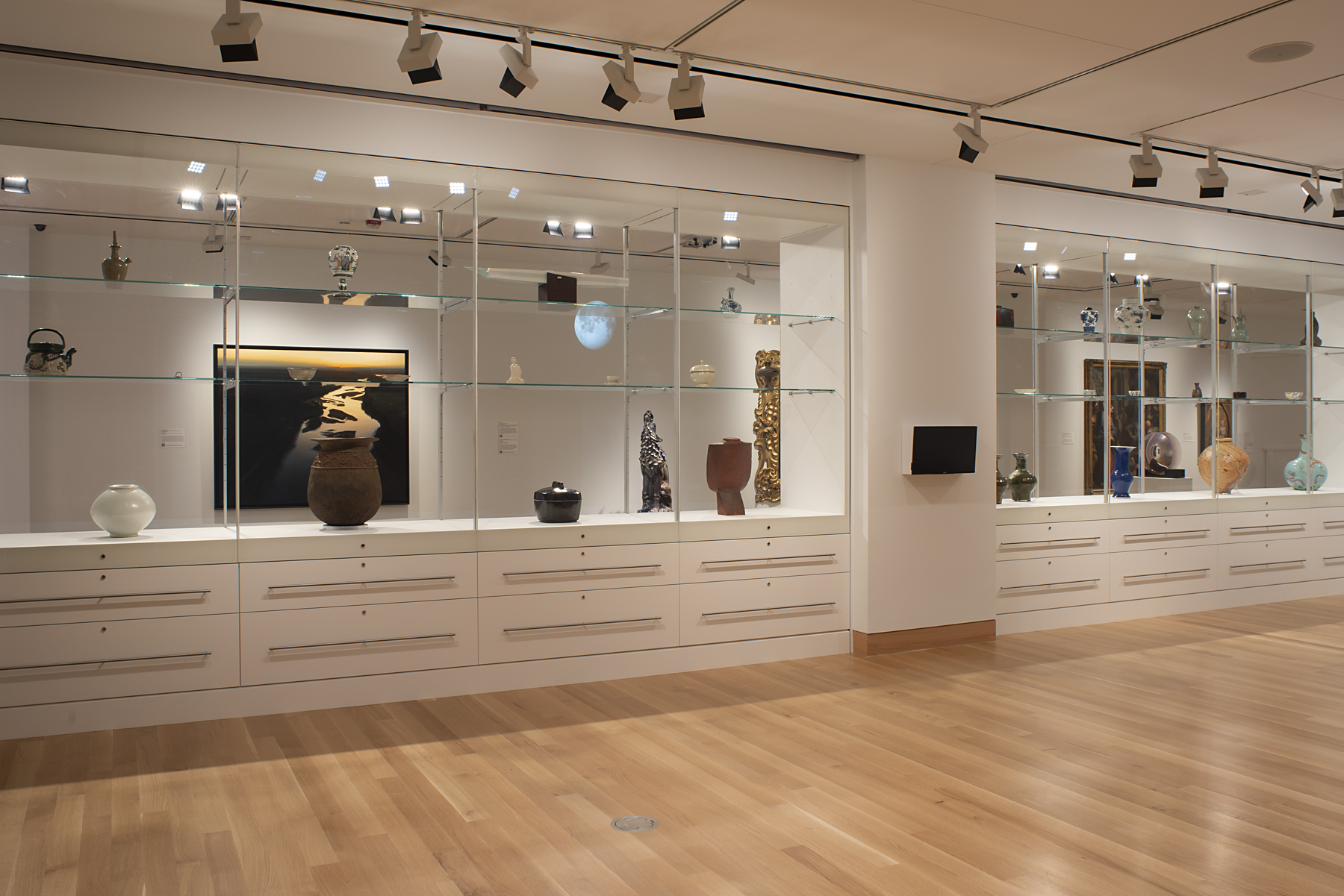 A wall of glass cases holds works of art in various shapes and sizes