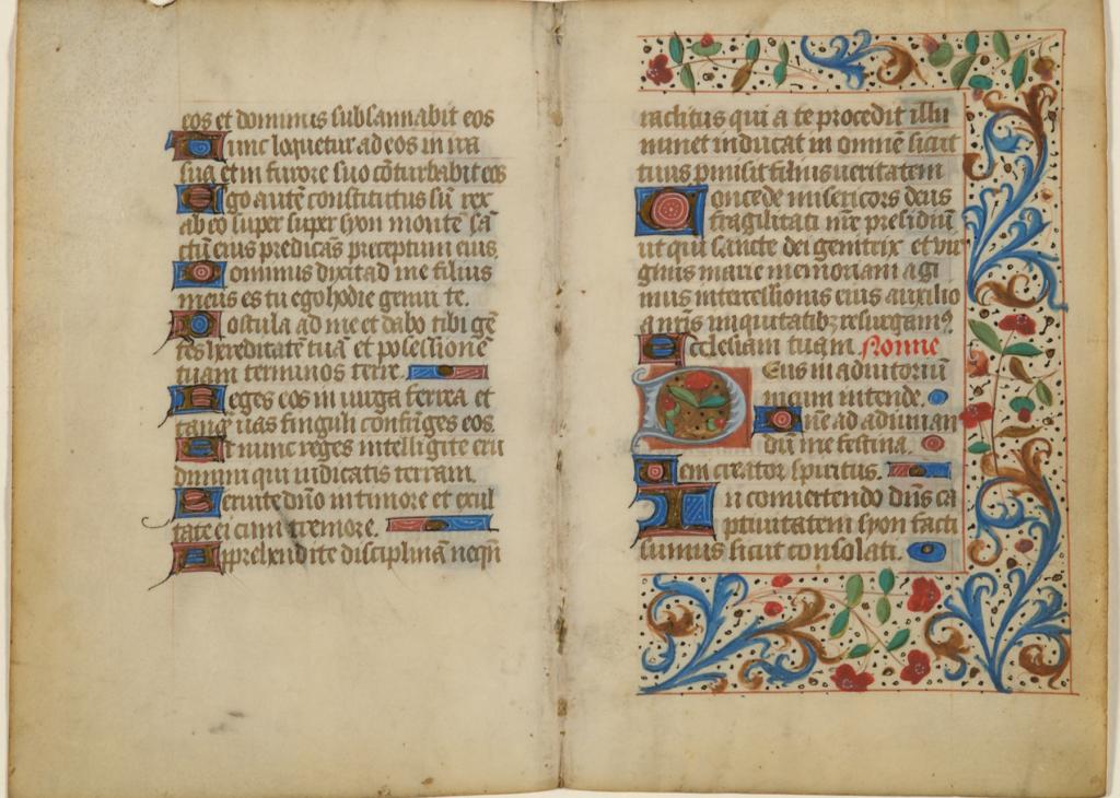 An open book with cream-colored pages and handwritten text decorated with bright flourishes of color