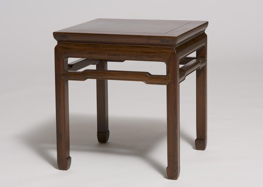 A brown, square wooden stool with four legs