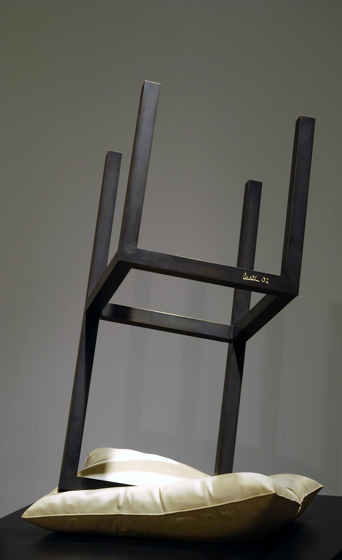 An upside down chair balances on a pillow