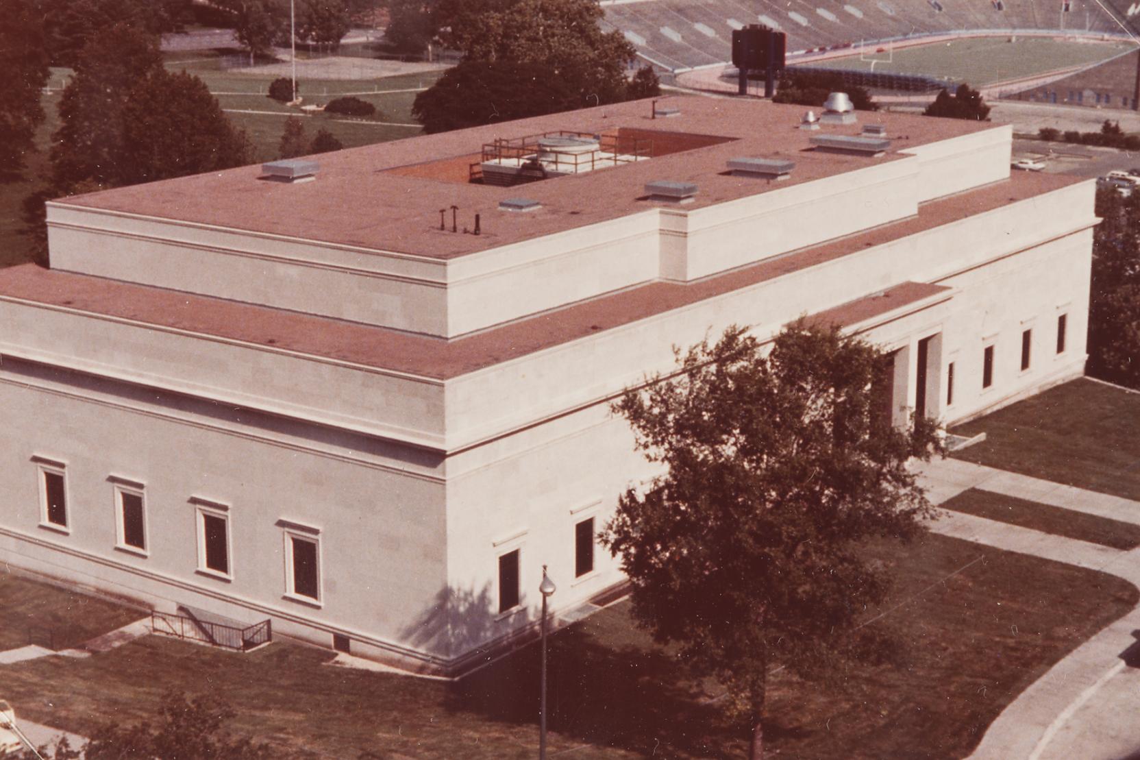 Photo of a classical white marble building near a football stadium
