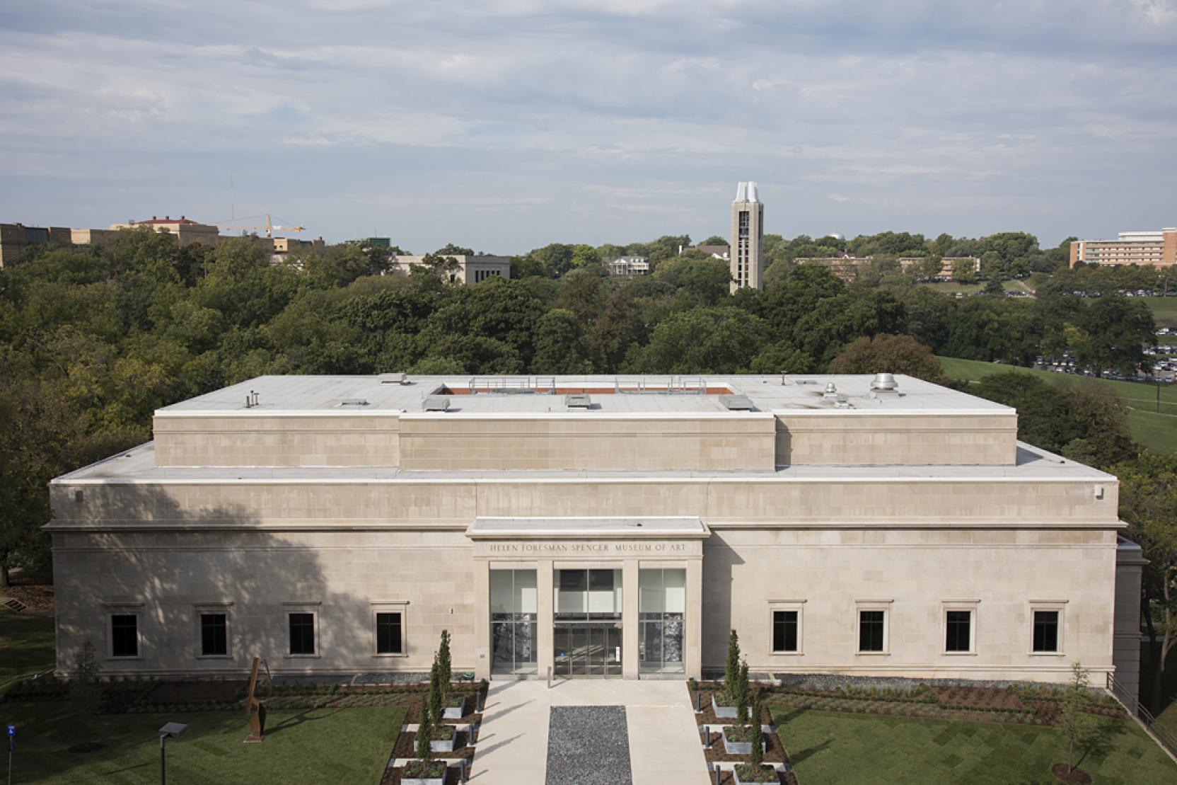 Aerial view of a three-story classic stone building with one row of windows on the ground floor