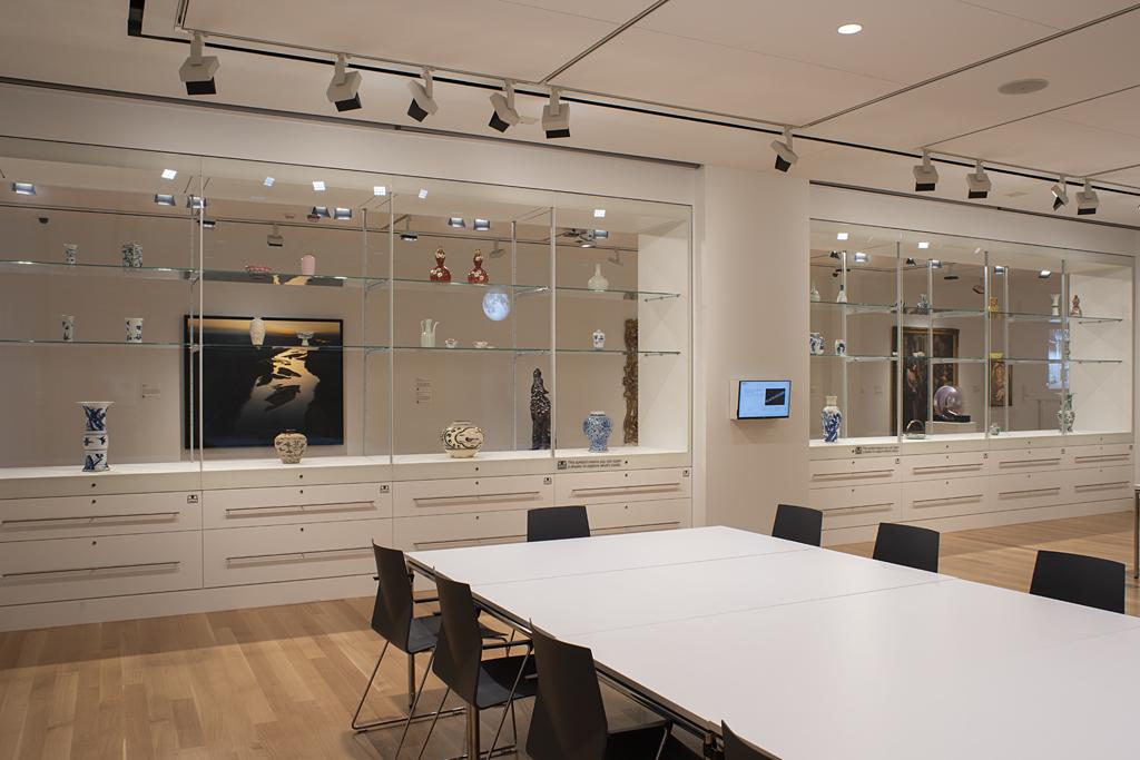 A wall of glass cases with ceramic objects inside