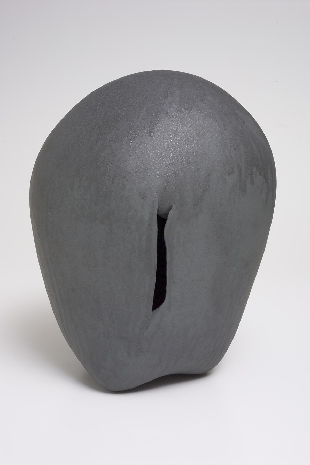 Closed, egg-shaped form in gray with a slender cut through the side