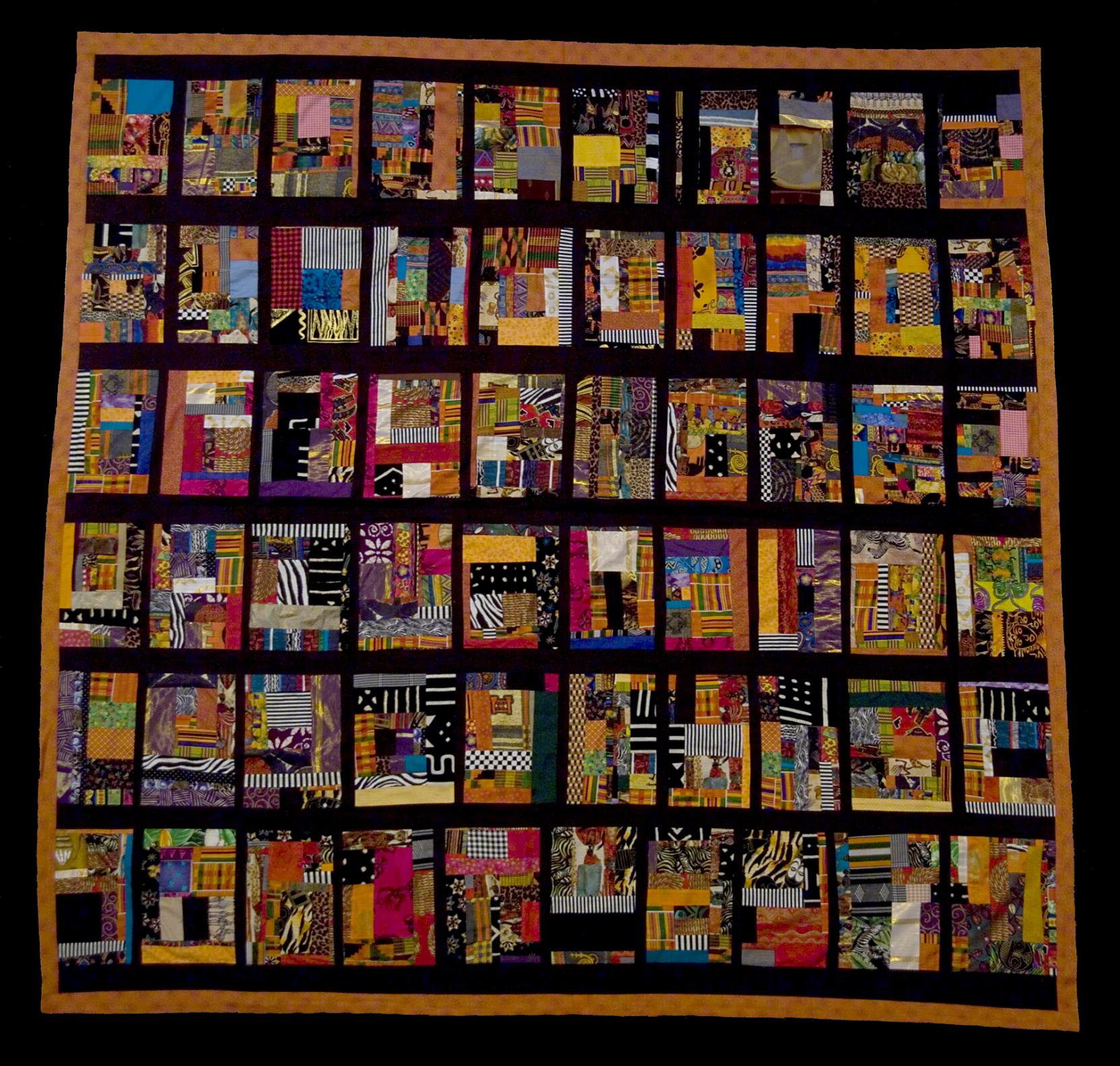 A quilt of colorful rectangles in a grid pattern on a black background with an orange boarder; each rectangle is made of printed fabrics layered and sewn together 