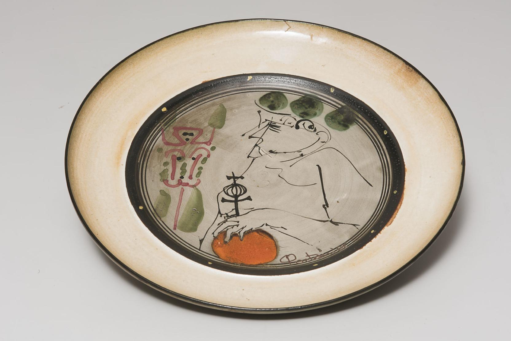 Plate decorated with a line drawing of a figure holding an orange orb topped with a cross and an abstract form rendered in pink lines and green washes