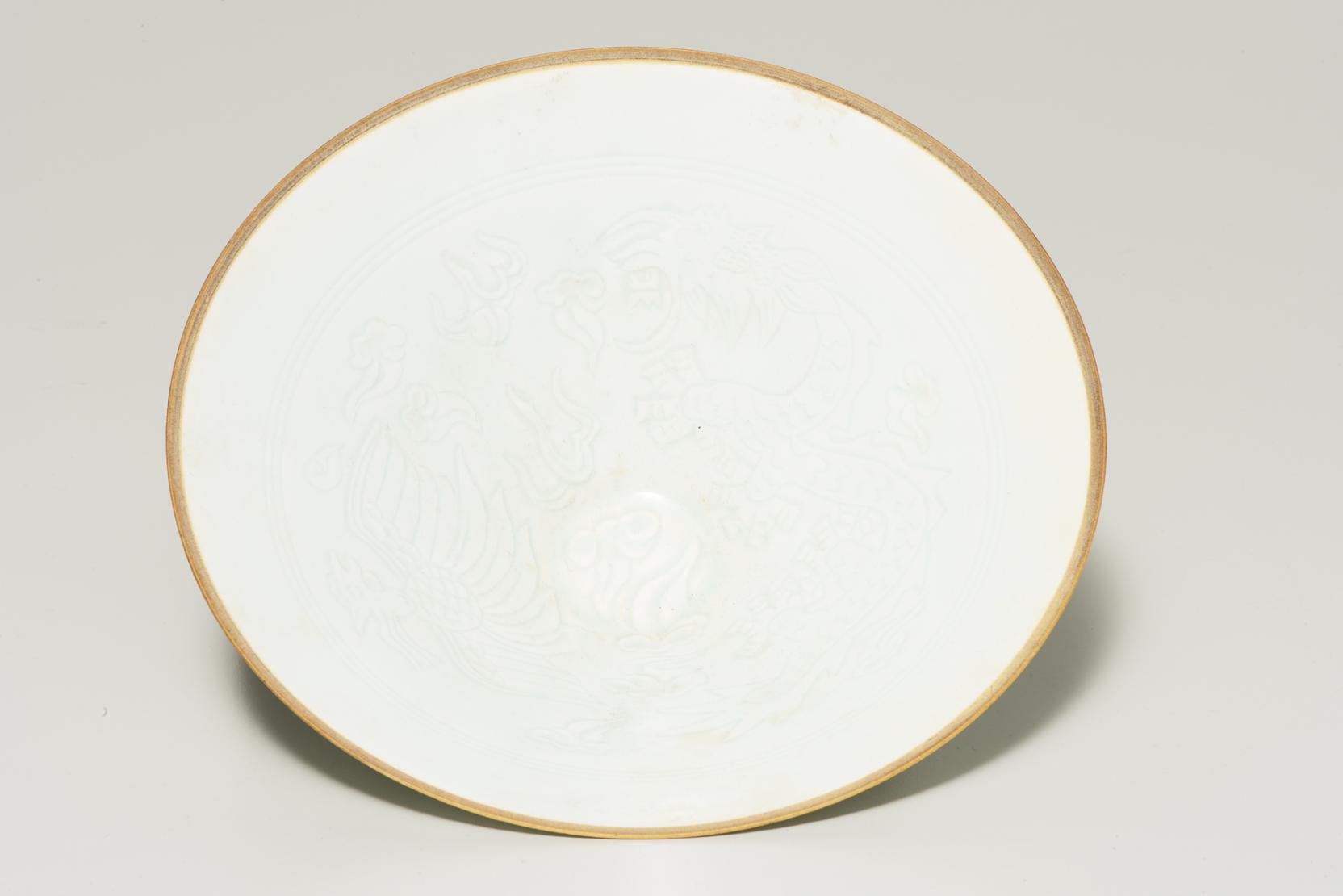 white bowl with barely visible decoration and a tan rim