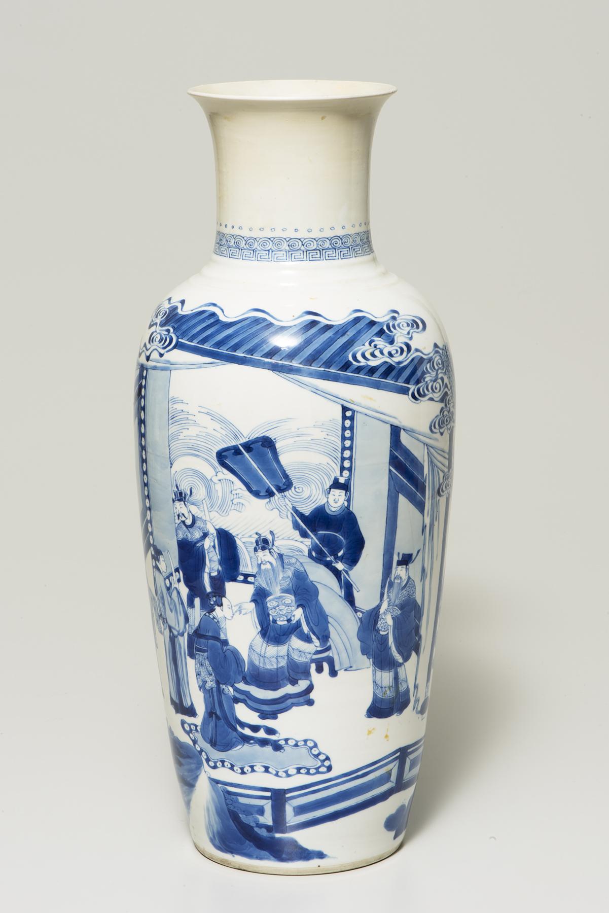 a tall white vase with a narrow neck is decorated in blue with a man presenting a gift to another man while others look on