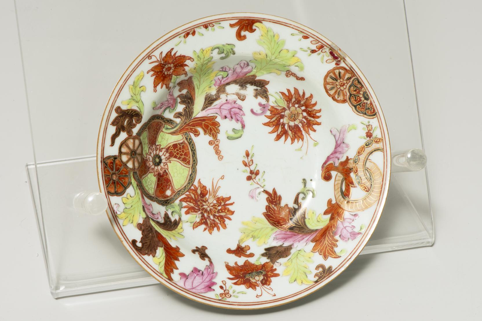 small white dish decorated with red flowers and green and light purple leaves