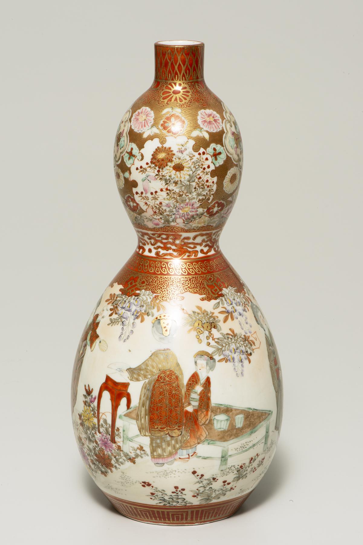 white, red, and gold vase with a large circular bottom decorated with two female figures, and a top smaller section with pink, orange, and red flowers